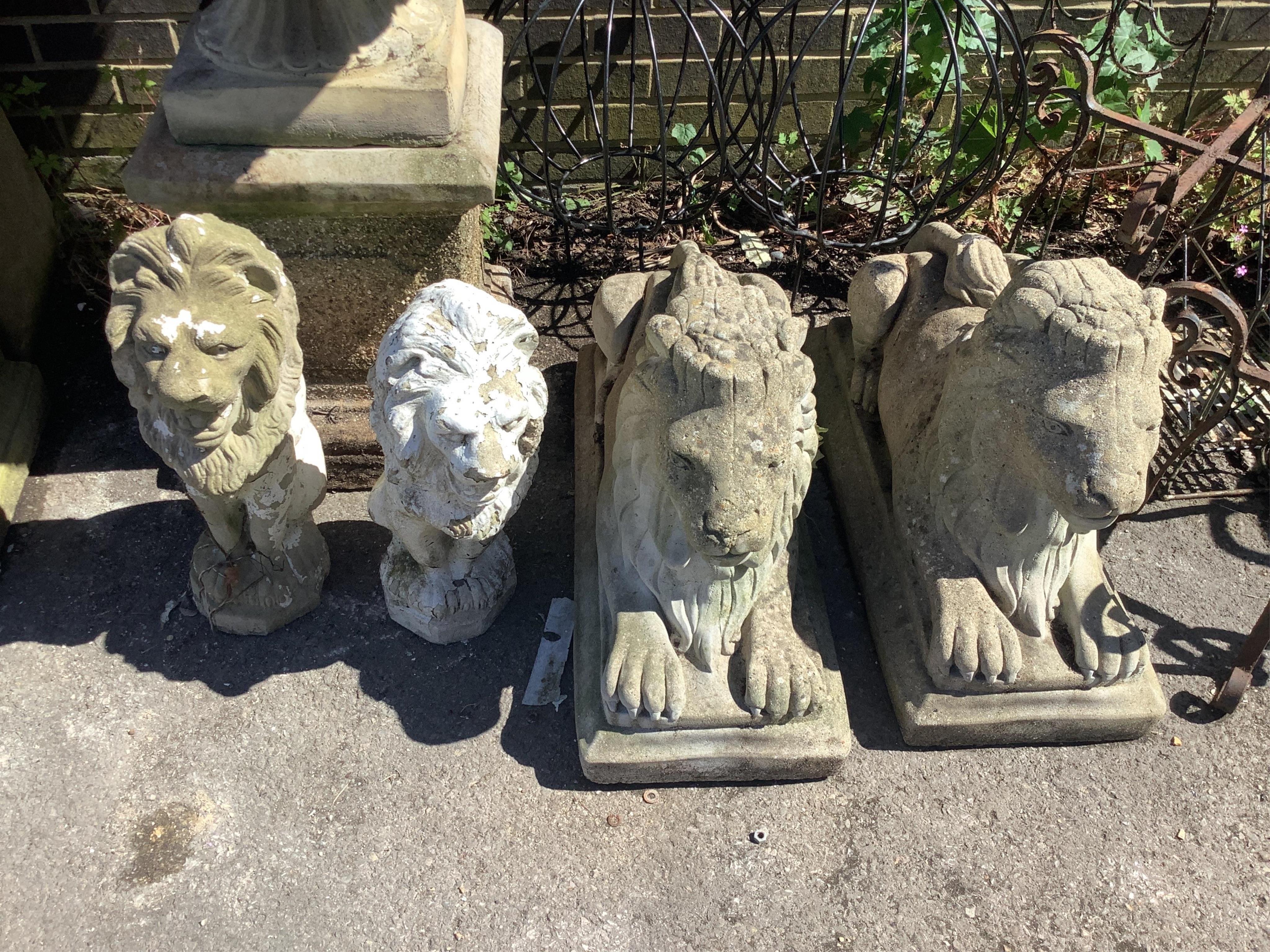 Two pairs of reconstituted stone recumbent and seated lion garden ornaments, larger width 72cm, height 50cm. Condition - fair
